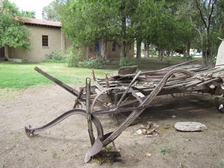 A private chapel can be seen from the far corner of the property, where an old wagon and plow sit as part of the display outside the building now housing the museum.